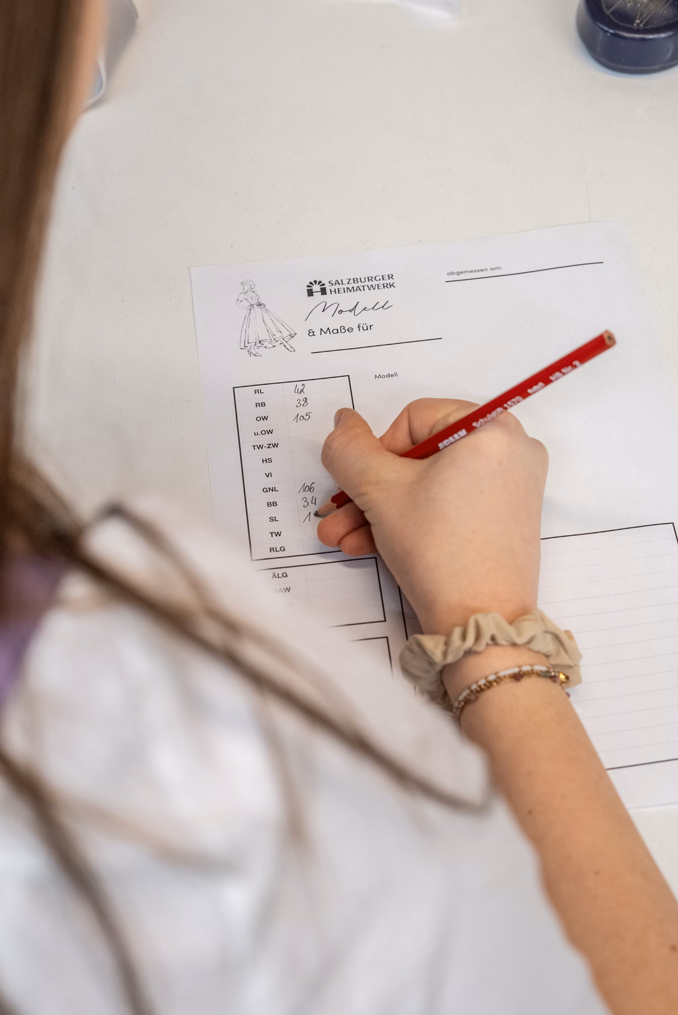 Iemand schrijft op een ontwerpblad.